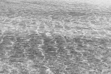 Küçük dalgalar ile kırılma ışık temiz su. Siyah ve beyaz fotoğraf