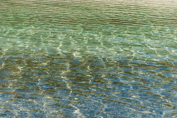 Refraction of light in clear water with small waves