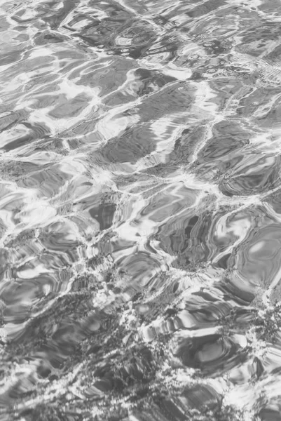 在有小波浪的清澈水中折射光线 黑白照片 — 图库照片