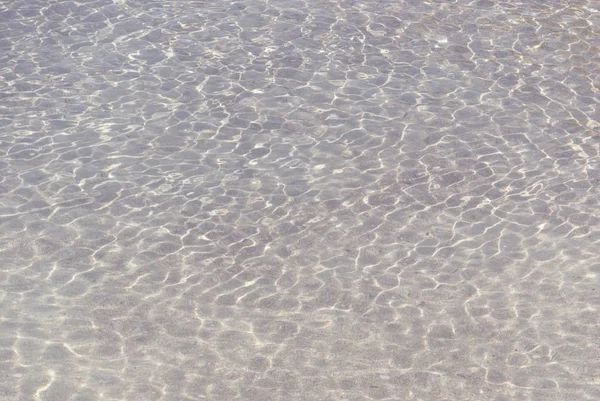 在有小波浪的清澈水中折射光线 色调照片 — 图库照片