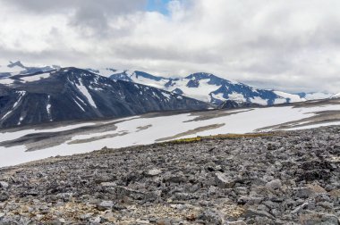 Kayalık yamaç Jotunheimen Milli Parkı, Norveç'te karla kaplı dağlar arka planı
