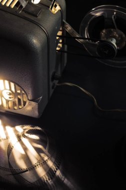 Karanlıkta eski sinema projektörü ve kasetler