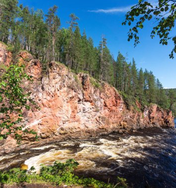 Fırtınalı nehrin üzerindeki kayalarda yüksek ladin, Finlandiya