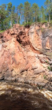 Fırtınalı nehrin üzerindeki kayalarda yüksek ladin, Finlandiya