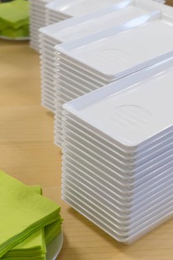 Bir masa üzerinde plastik tabak ve peçete yığını