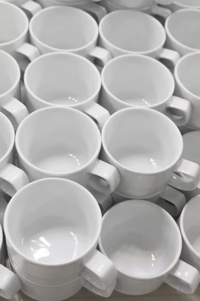 Una gran cantidad de vasos de porcelana blanca vacía en una mesa — Foto de Stock