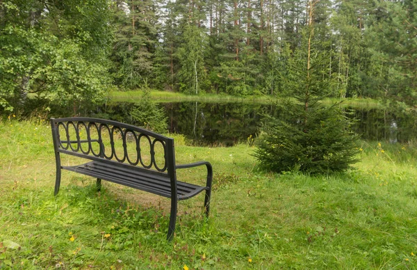 Stary metalowy kute Ława na brzegu jeziora — Zdjęcie stockowe