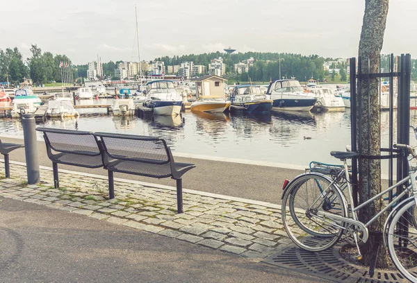 Bankjes, fietsen en boten op de dijk van Jyvaskyla, Finl — Stockfoto