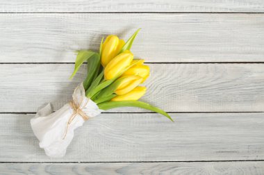 Beyaz ahşap masa üzerinde Sarı Lale buketi