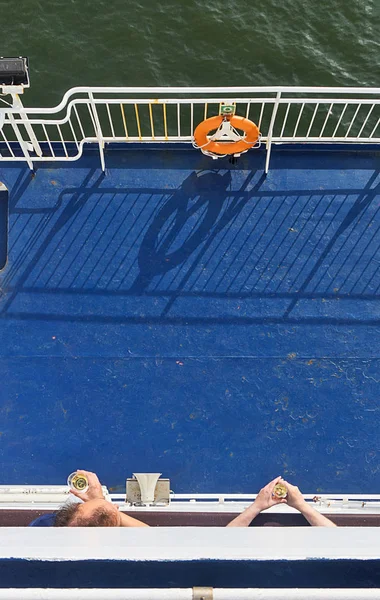 Men's hands holding glasses of wine on a ship deck — Stock Photo, Image