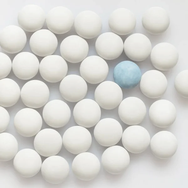 Um azul e muitos comprimidos brancos — Fotografia de Stock