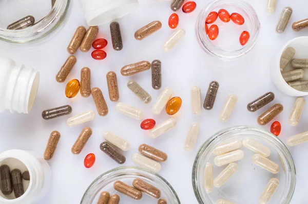 Capsula, pillole e barattoli medicinali su una superficie leggera — Foto Stock