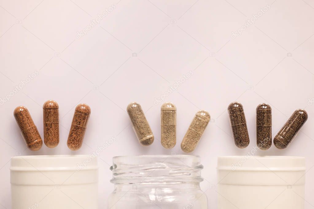Medicinal capsule spill out of a three plastic bottles