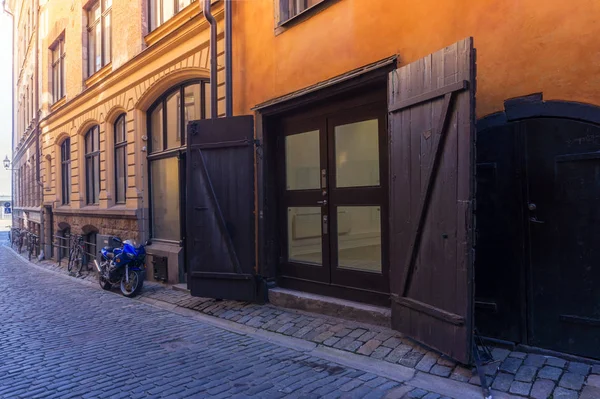 Motorcycle and wooden gate on the Old Town street in Stockholm, — Stock Photo, Image