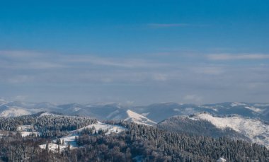 Karla kaplı ormanlık dağın panoraması
