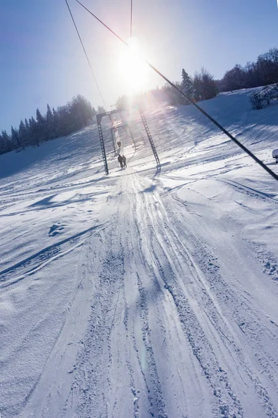 Skiërs op een skilift op een berghelling — Stockfoto