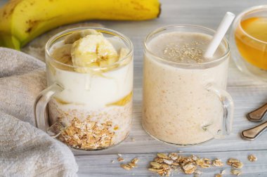 Malzemeler muz, bal, yulaf ezmesi ve yoğurt ve smoothie ile iki cam bardak