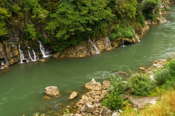 Kayalık kıyıları olan bir dağ nehrinde şelaleler