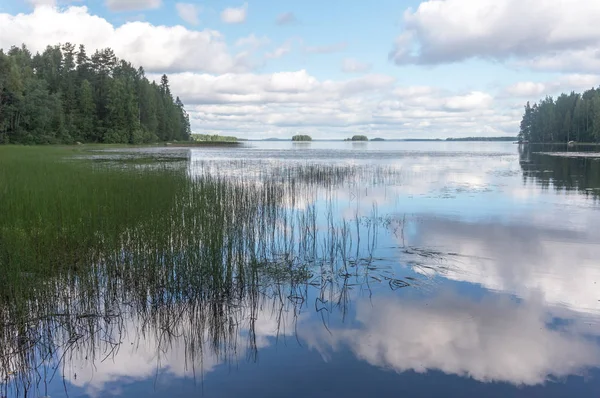 Nuvens brancas e céu azul refletido em um lago tranquilo — Fotografia de Stock