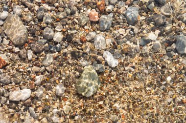 Berrak su ve denizde renkli çakıl taşları