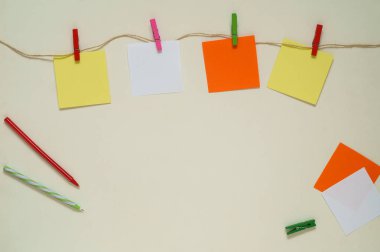 Bir ip üzerinde clothespins ile çok renkli kağıt çıkartmalar