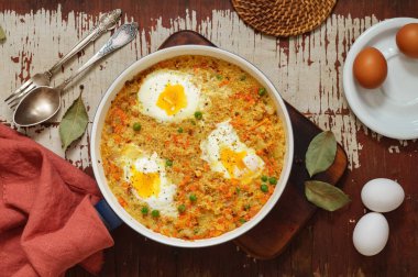 Beyaz bir tavada sebze ve yumurta ile Buğday lapası