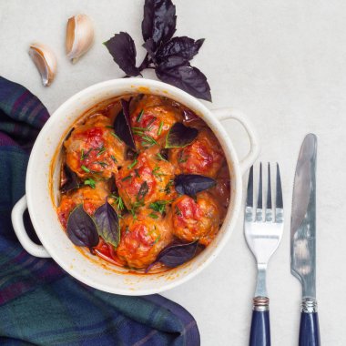 Fesleğen ve ga ile bir tencerede domates sosu içinde haşlanmış Köfte