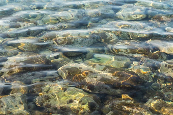 Tiszta víz és színes kavicsok a tengeren — Stock Fotó