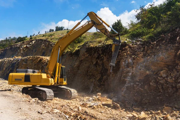 Hydraulic hammer destroys rock in road construction