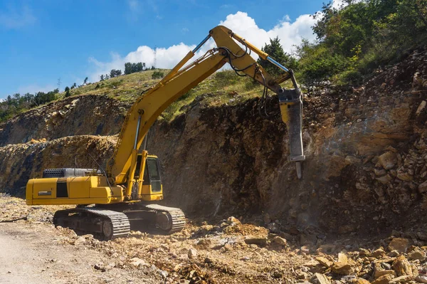 Hydraulic hammer destroys rock in road construction
