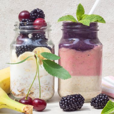 Katmanlı kiraz, muz, böğürtlen smoothie, yoğurt ve yulaf ezmesi ve malzemeler