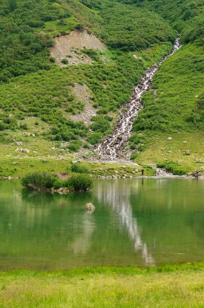 Pintoresco lago tranquilo y arroyo en colinas verdes — Foto de Stock