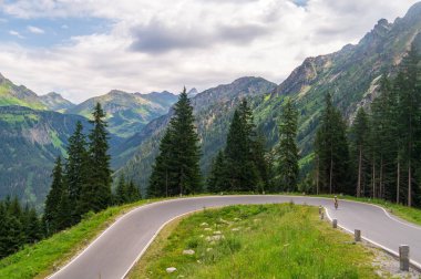 Bir dağ turistinin yılanı Silvretta High Alpine Road, Avusturya 'yı geçiyor.