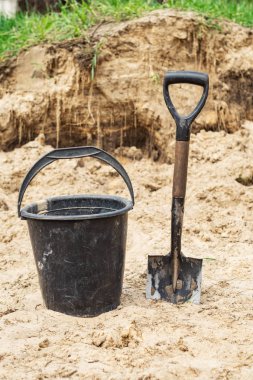 Kumda siyah plastik kova ve kürek.