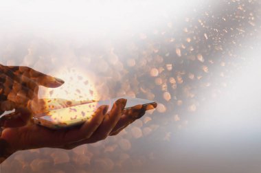 Soyut parlayan plazma ba ile akıllı telefon tutan bir kadın.