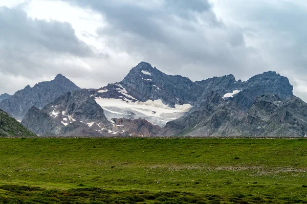 Montagne rocciose con neve ed erba verde nelle Alpi austriache — Foto Stock