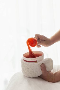 Beyaz bir kavanozda kırmızı şeffaf karıştırıcı macun.