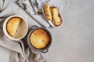 İki tabak süzme peynir güveci ve gri masadaki bir tabak dolusu güveç.