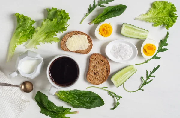 Desayuno saludable. Taza de café, huevos, tostadas con mantequilla y hojas de espinacas — Foto de Stock
