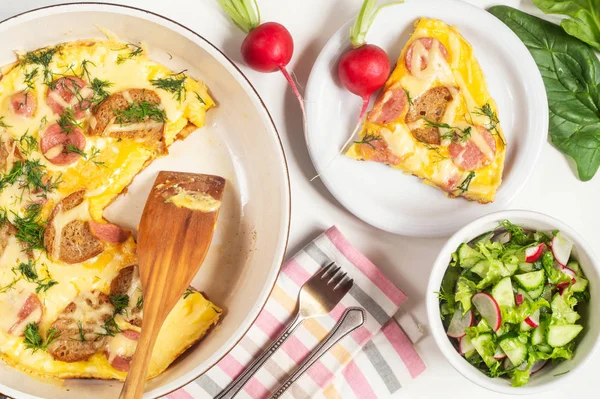 Tortilla con croutons, salchichas, queso y eneldo en una sartén — Foto de Stock