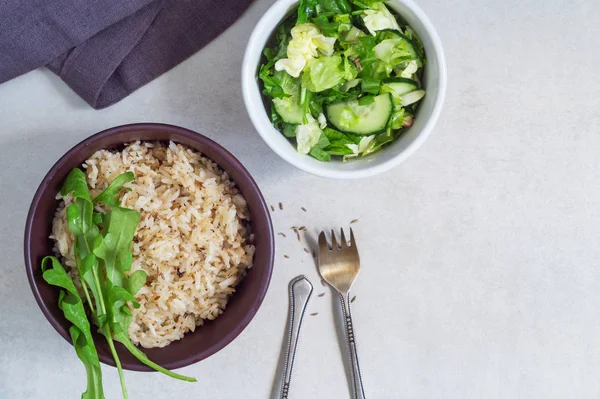 Чаша риса со специями и овощным салатом на сером фоне — стоковое фото