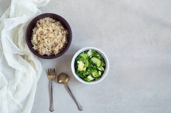 Чаша риса со специями и овощным салатом на сером фоне — стоковое фото