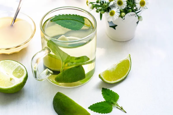 Lime tea with mint in a glass cup, honey and chamomile — Stock Photo, Image