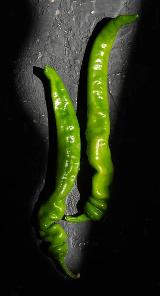 Groene hete paprika 's op een donkere stenen achtergrond — Stockfoto
