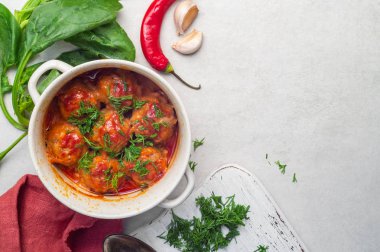 Köfte, tencerede domates sosu, otlar, biber ve sarımsak.