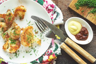 Ekmek kırıntılarında kızartılmış karnabahar ve beyaz bir tabakta dereotu.