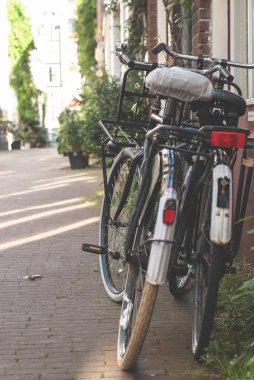 Amsterdam, Hollanda 'da eski bir binanın duvarına parketmiş bisikletler.