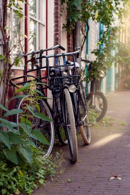 Amsterdam, Hollanda 'da eski bir binanın duvarına parketmiş bisikletler.
