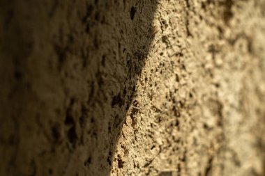 Kerpiç duvarındaki ışık ve gölge. Çamur alçı dokusu. Yakın plan.