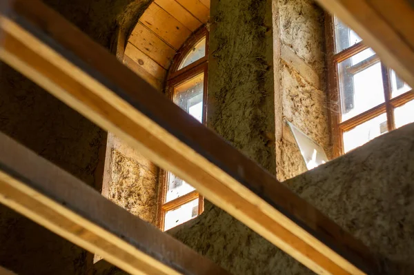 İnşaat sırasında kil alçılı ahşap bir eko evin yapıları ve pencereleri. Alt yaşam